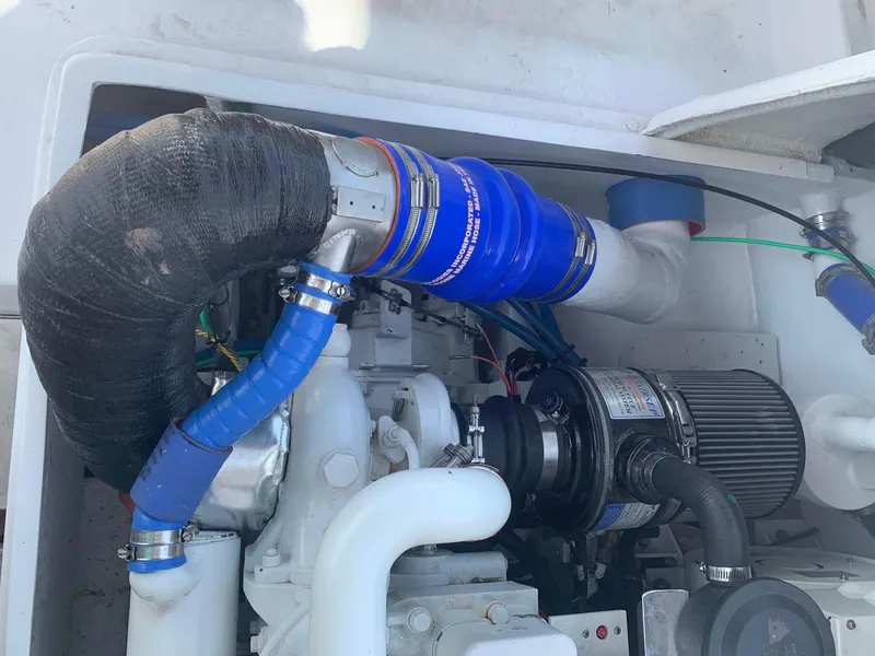 Slide: The Image of Engine compartment of a 1974 Bertram 31 Flybridge Cruiser with visible hoses and components. - 23