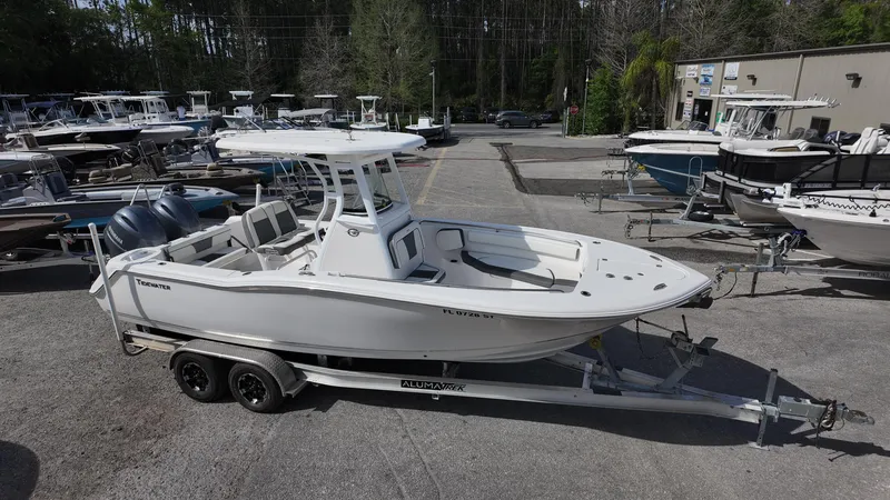 Slide: The Image of 2020 Tidewater 252 CC Adventure boat on trailer in marina setting. - 11