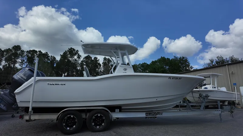 Slide: The Image of 2020 Tidewater 252 CC Adventure boat on trailer under blue sky. - 13