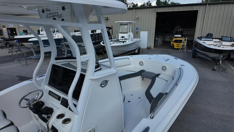 Slide: The Image of 2020 Tidewater 252 CC Adventure boat at a marina, showcasing its spacious deck and seating. - 21