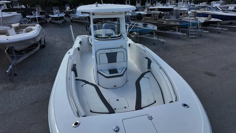 Slide: The Image of 2020 Tidewater 252 CC Adventure boat, white exterior, docked among other boats. - 26