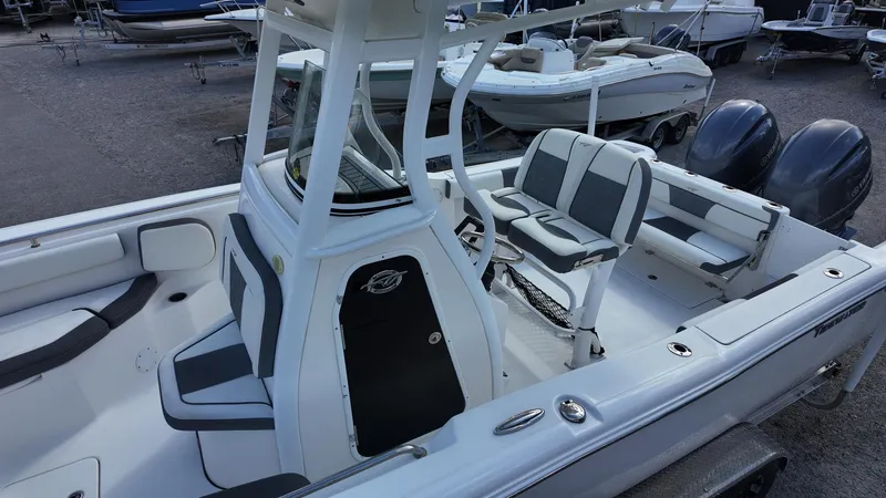 Slide: The Image of 2020 Tidewater 252 CC Adventure boat with dual engines and seating, docked in a marina. - 29