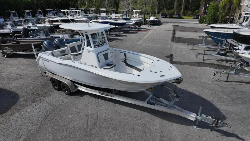 Slide: The Image of 2020 Tidewater 252 CC Adventure boat on trailer in marina setting. - 7