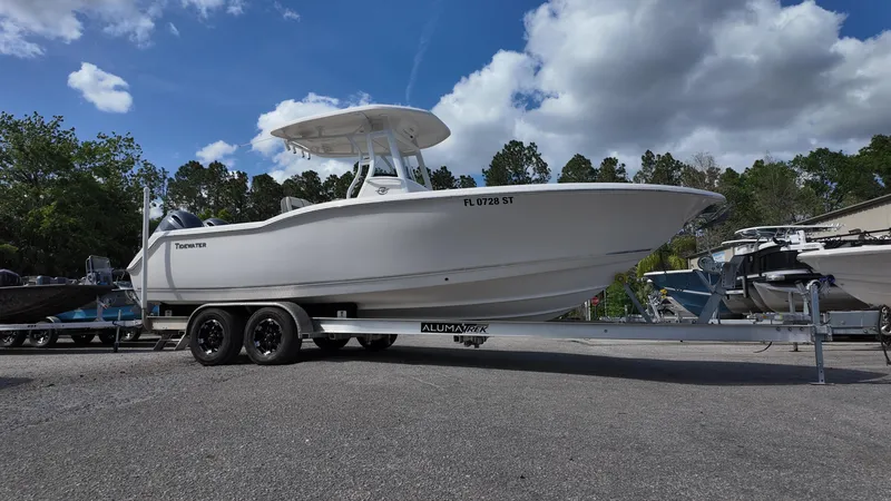 Slide: The Image of 2020 Tidewater 252 CC Adventure boat on trailer under cloudy sky. - 8
