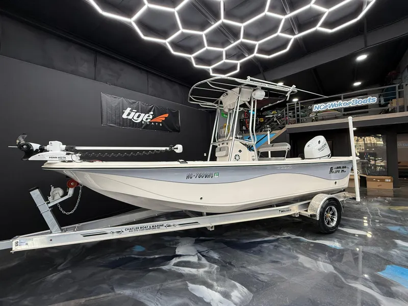 Slide: The Image of 2024 Carolina Skiff 21 LS boat on trailer in showroom with modern lighting. - 1