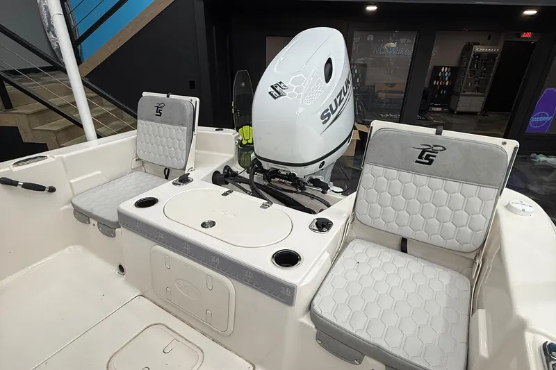 Slide: The Image of 2024 Carolina Skiff 21 LS boat interior with Suzuki outboard motor and cushioned seating. - 10