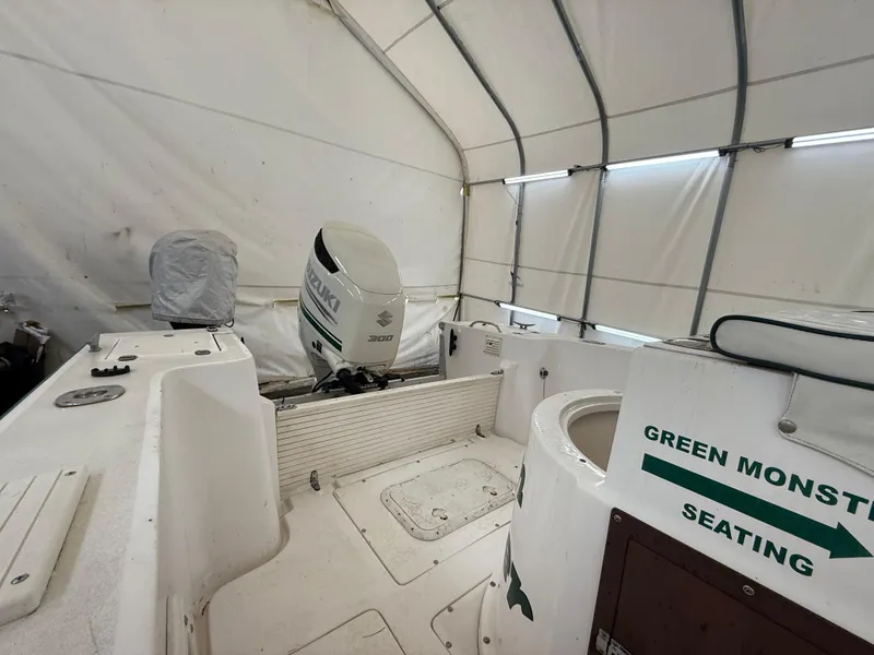 Slide: The Image of 1996 Mako 241 boat interior with Suzuki outboard motor in covered storage. - 12