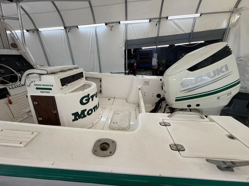 Slide: The Image of 1996 Mako 241 boat with Suzuki outboard motor in covered storage. - 13