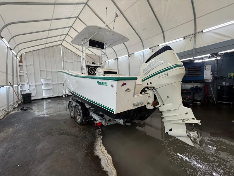 Slide: The Image of 1996 Mako 241 boat in a covered storage area, featuring a powerful outboard motor. - 3