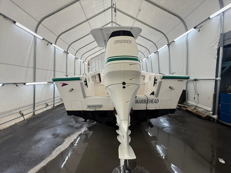 Slide: The Image of 1996 Mako 241 boat in storage, featuring a powerful outboard motor. - 4