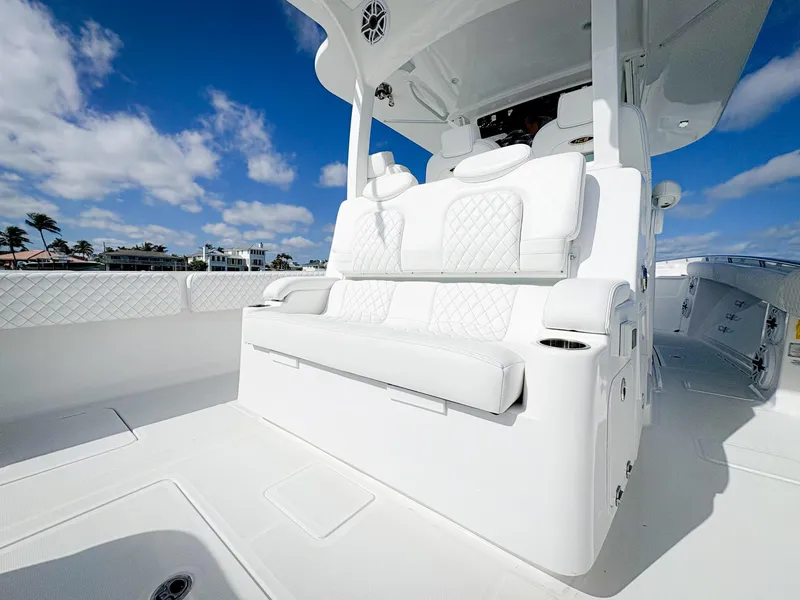 Slide: The Image of 2023 HCB 39 Speciale boat interior with luxurious white seating under a clear blue sky. - 17