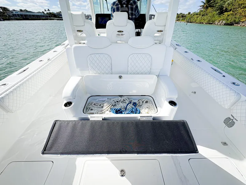 Slide: The Image of 2023 HCB 39 Speciale boat interior with seating and storage, docked by the water. - 19