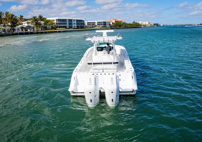 Slide: The Image of 2023 HCB 39 Speciale boat cruising on clear blue water near coastal buildings. - 2