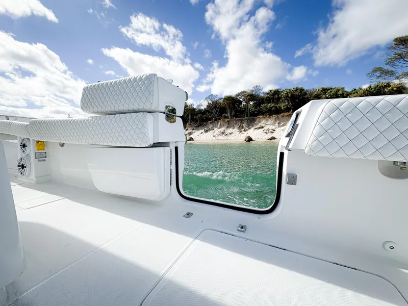 Slide: The Image of 2023 HCB 39 Speciale boat interior with white seating, overlooking a scenic coastal view. - 31