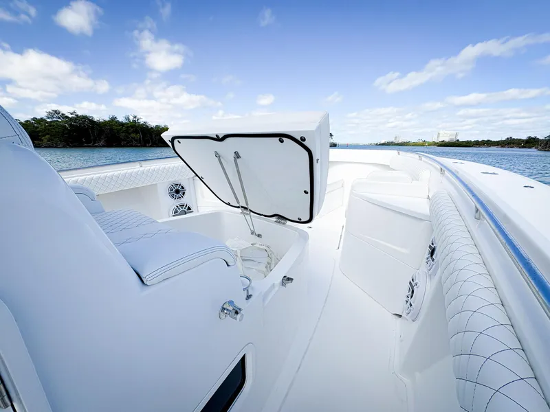 Slide: The Image of 2023 HCB 39 Speciale boat interior with open storage, white seating, and scenic water view. - 36