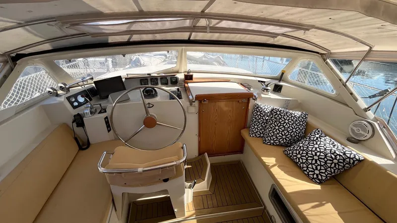 Slide: The Image of 1996 Amel Super Maramu-53 yacht cockpit with steering wheel, seating, and nautical decor. - 12