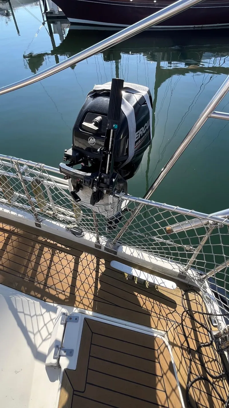 Slide: The Image of Outboard motor on 1996 Amel Super Maramu-53 sailboat, docked with safety netting. - 18