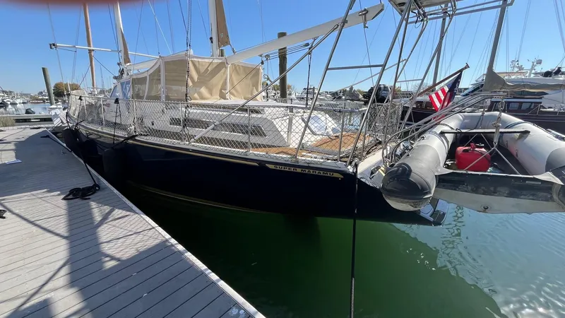 Slide: The Image of 1996 Amel Super Maramu-53 sailboat docked, featuring sleek design and American flag. - 3