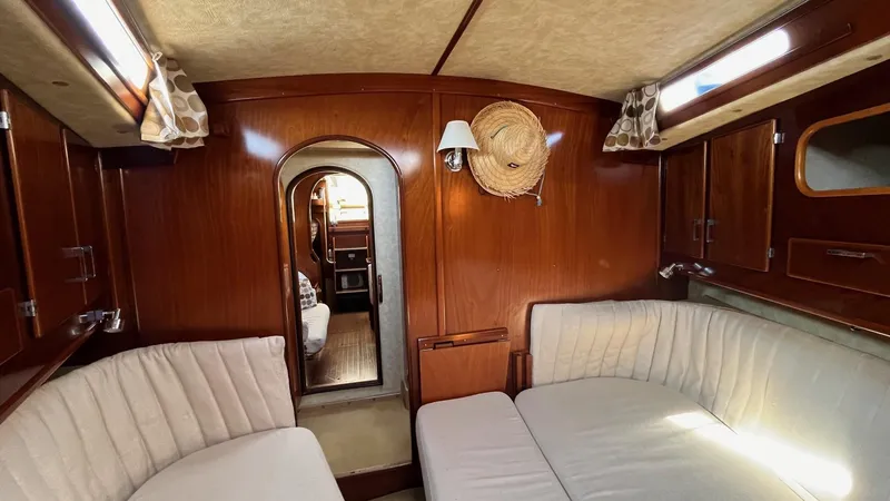 Slide: The Image of Interior of 1996 Amel Super Maramu-53 yacht with wooden paneling and cushioned seating. - 31