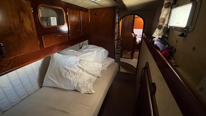 Slide: The Image of Cozy cabin interior of 1996 Amel Super Maramu-53 sailboat with wooden paneling and bedding. - 36