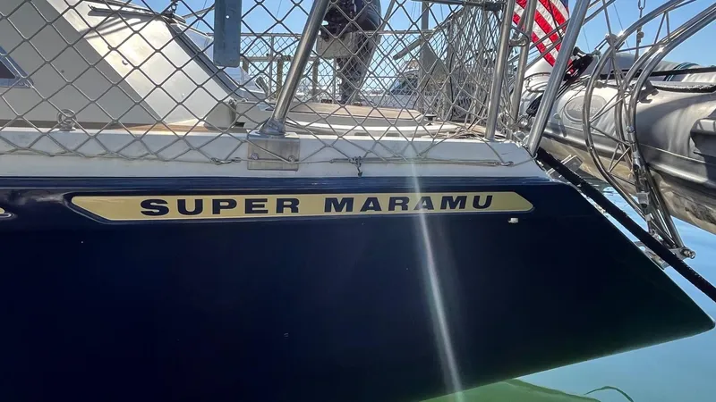 Slide: The Image of 1996 Amel Super Maramu-53 sailboat docked, featuring nameplate and railing. - 4