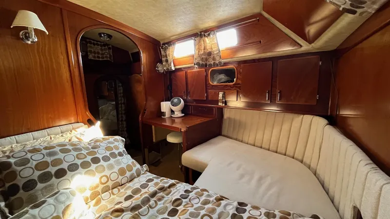 Slide: The Image of Cozy cabin interior of 1996 Amel Super Maramu-53 sailboat with bed, seating, and wooden decor. - 40