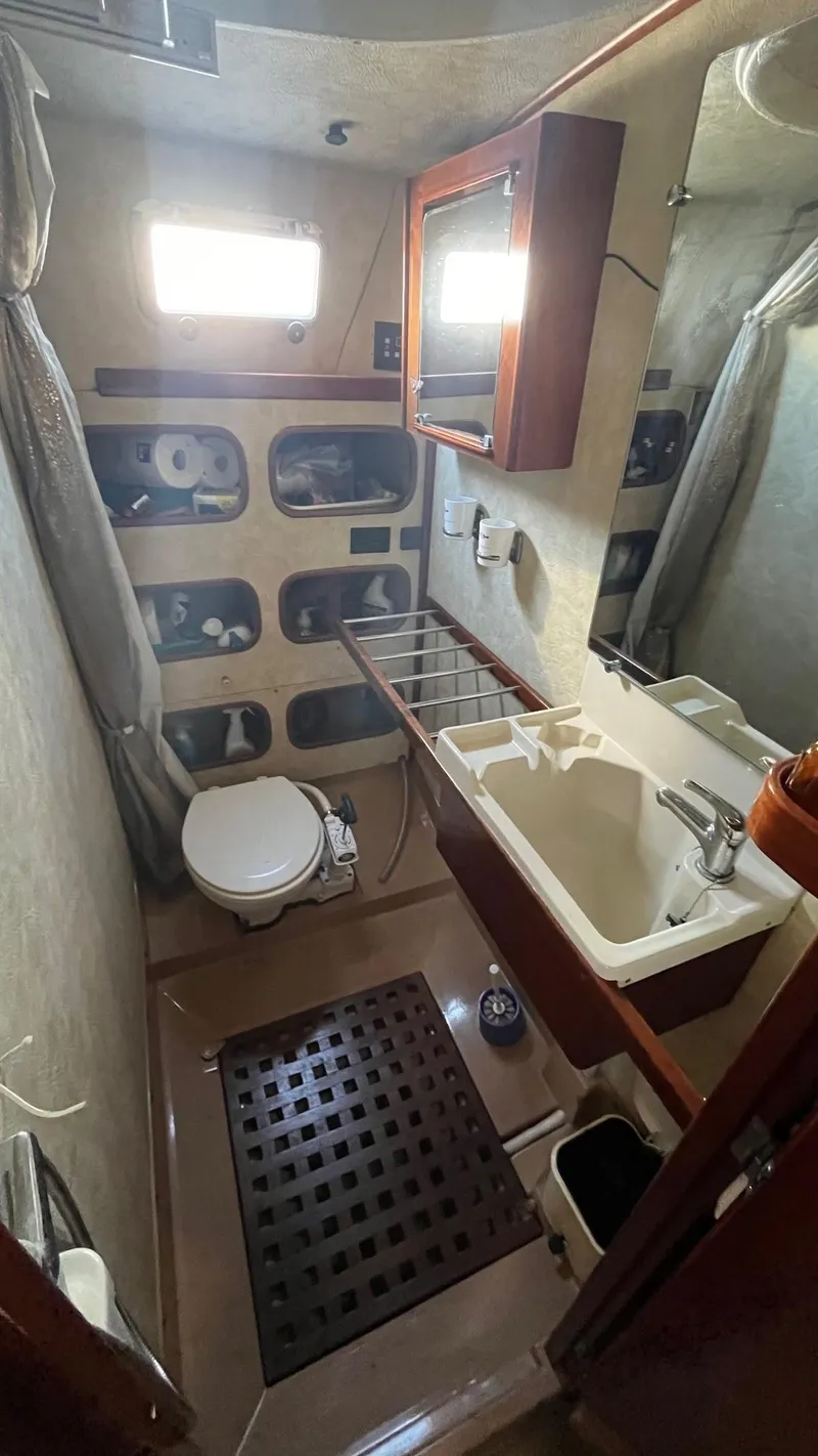 Slide: The Image of 1996 Amel Super Maramu-53 yacht bathroom with sink, toilet, and storage shelves. - 44