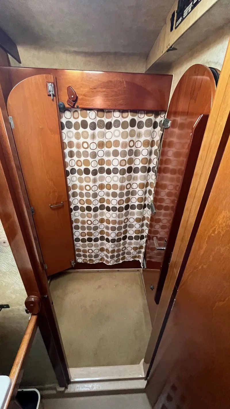 Slide: The Image of Shower area in a 1996 Amel Super Maramu-53 yacht with wooden accents and patterned curtain. - 45
