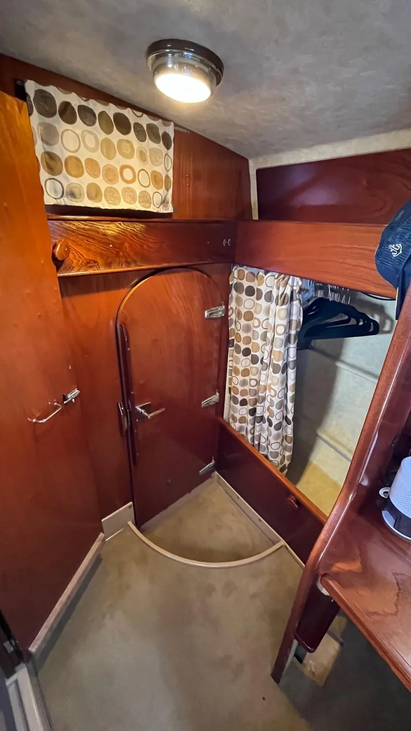 Slide: The Image of Interior of 1996 Amel Super Maramu-53 sailboat with wooden cabinetry and circular window. - 46
