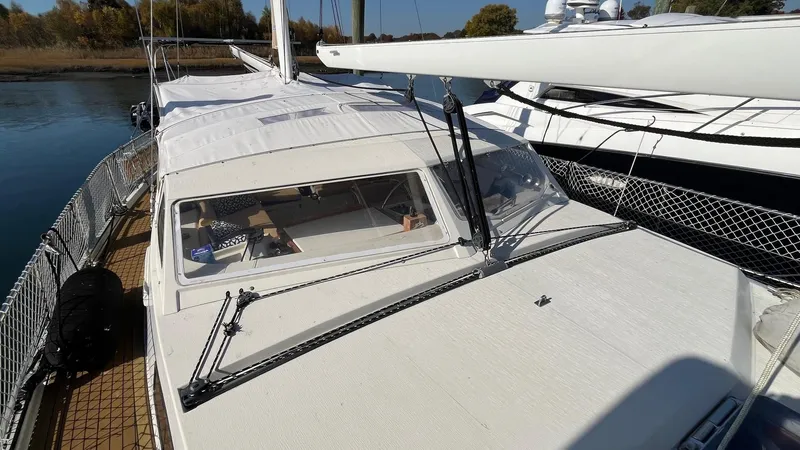 Slide: The Image of 1996 Amel Super Maramu-53 sailboat docked, featuring a sleek white deck and cabin. - 6