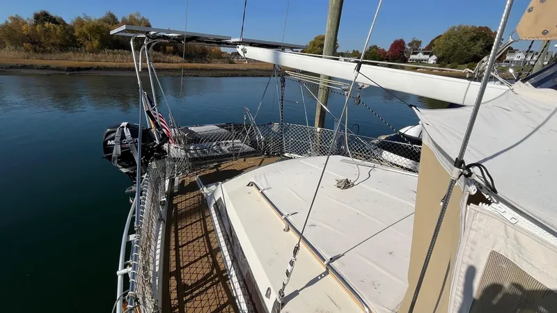 Slide: The Image of 1996 Amel Super Maramu-53 sailboat docked on calm water, surrounded by autumn trees. - 9