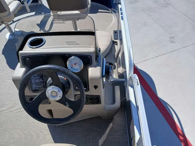Slide: The Image of 2025 Sun Tracker Bass Buggy 16 XL Select boat steering console with beige seating. - 4