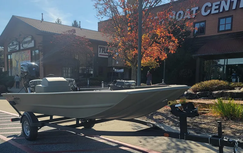 Slide: The Image of 2025 Tracker Grizzly 1754 SC boat on trailer outside a boat center. - 4