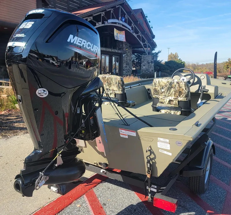 Slide: The Image of 2025 Tracker Grizzly 1754 SC boat with Mercury engine, parked outdoors. - 6