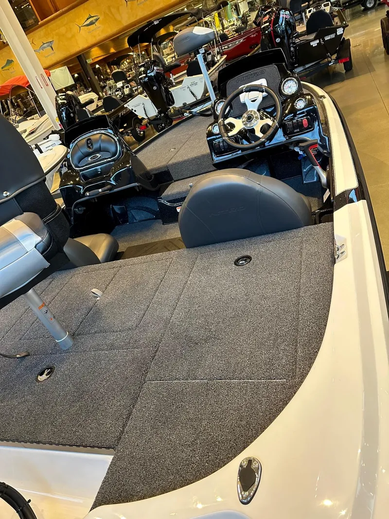 Slide: The Image of 2025 Nitro Z17 boat interior with steering wheel and seating, displayed in a showroom. - 2