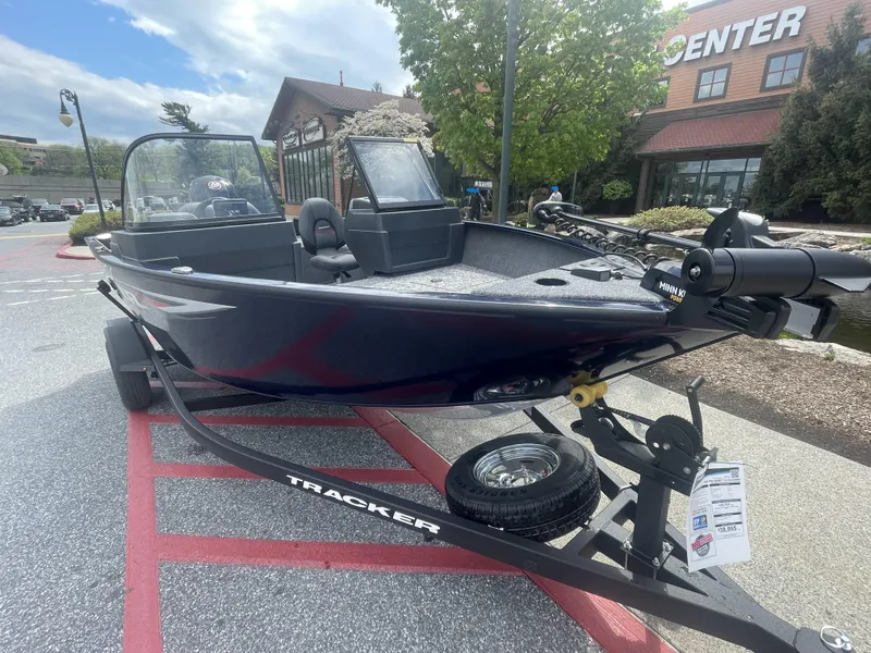 Slide: The Image of 2025 Tracker Pro Guide V-175 Combo boat on trailer, parked outdoors near a building. - 2