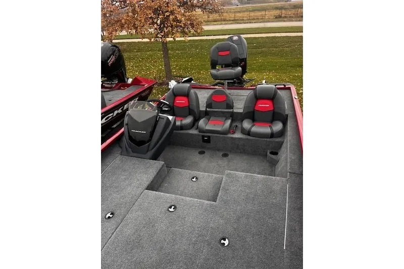 Slide: The Image of 2025 Tracker Savage 215 boat interior with gray and red seating, outdoor setting. - 88