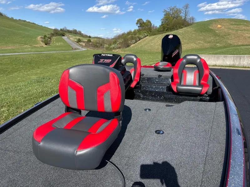 Slide: The Image of 2025 Nitro Z19 boat on trailer, parked on road with scenic green hills in background. - 3