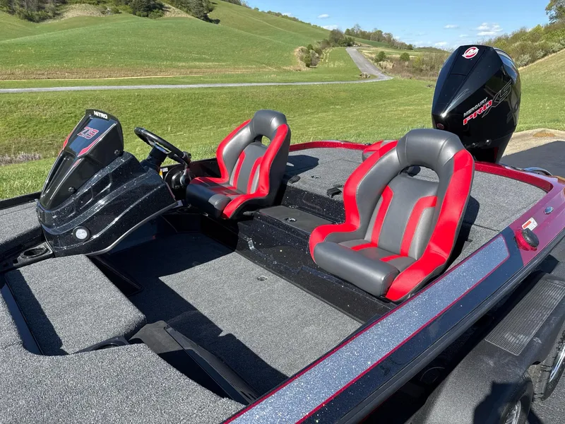 Slide: The Image of 2025 Nitro Z19 boat with red and gray seats, parked on a grassy landscape. - 5