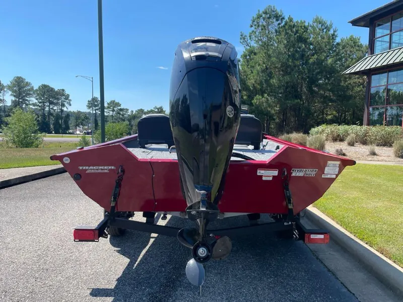 Slide: The Image of 2025 Tracker Pro Team 175 Crappie Edition boat, red, parked outdoors, rear view. - 4