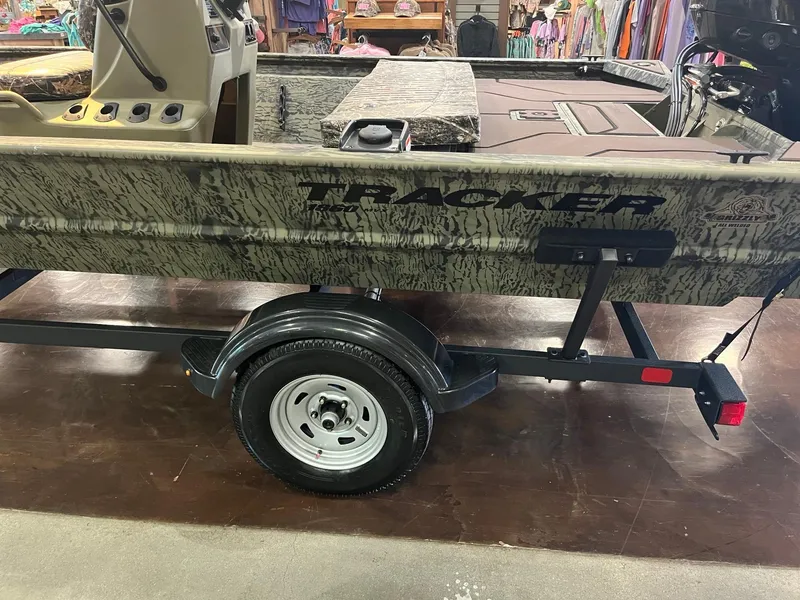 Slide: The Image of 2025 Tracker Grizzly 1860 CC boat on trailer, displayed indoors. - 3