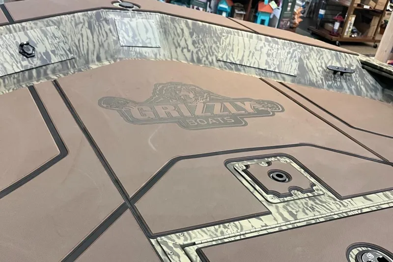 Slide: The Image of 2025 Tracker Grizzly 1860 CC boat deck with camo design and Grizzly Boats logo. - 4