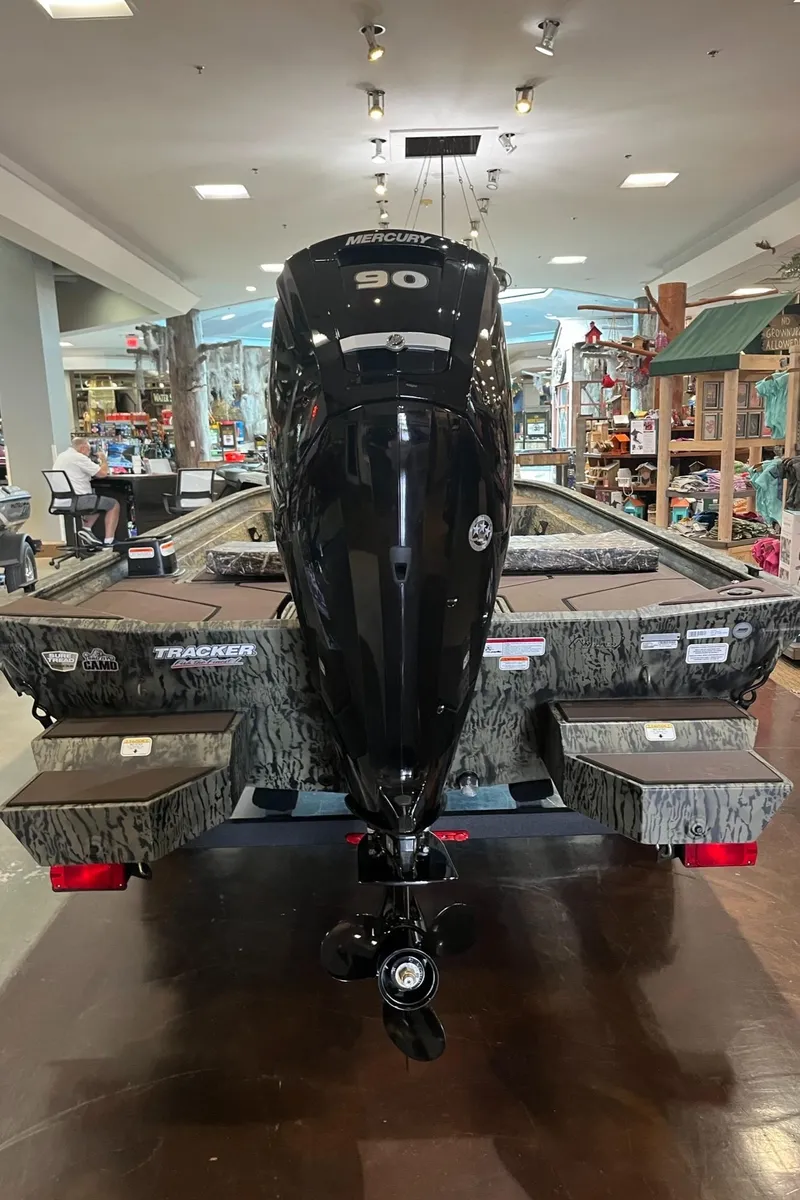 Slide: The Image of 2025 Tracker Grizzly 1860 CC boat with powerful outboard motor in showroom. - 6