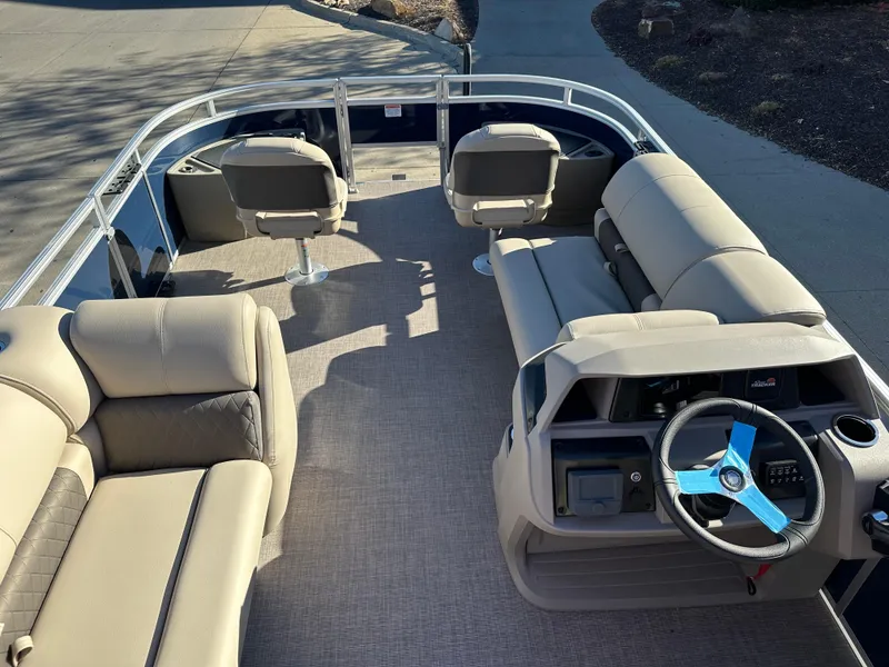 Slide: The Image of 2025 Sun Tracker Fishin' Barge 20 DLX interior with seating and steering wheel. - 3