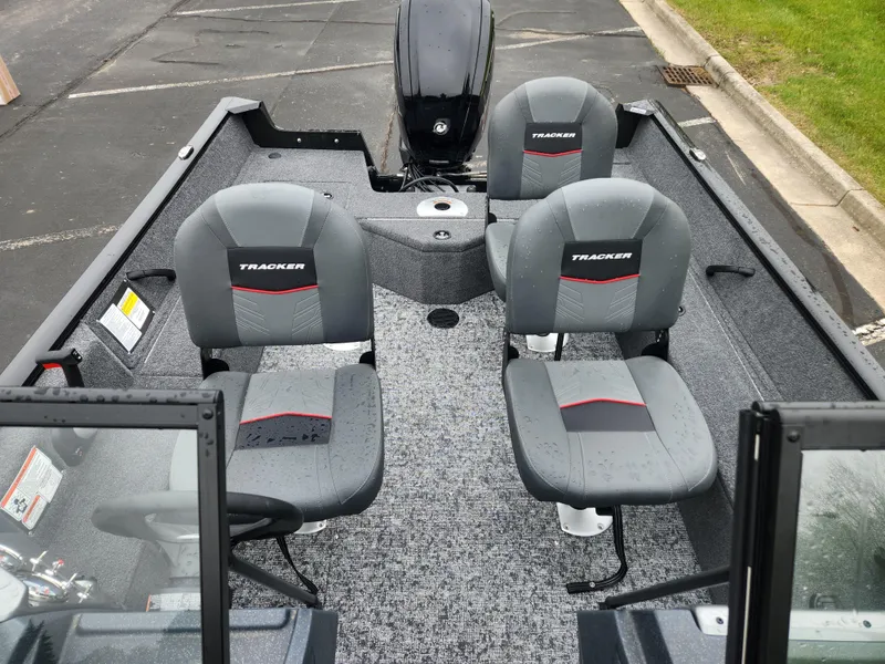 Slide: The Image of 2025 Tracker Pro Guide V-16 WT boat interior with four gray seats and motor. - 4