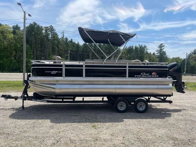Slide: The Image of 2025 Sun Tracker SportFish 20 DLX pontoon boat on trailer, parked outdoors. - 2
