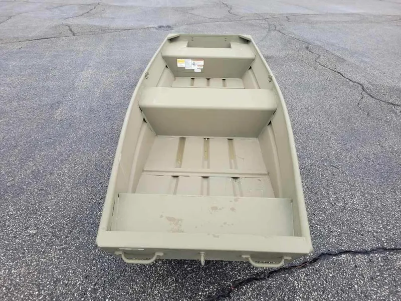 The Image of 2025 Tracker Grizzly 14 Jon boat on asphalt surface, showcasing interior seating and storage. - 0