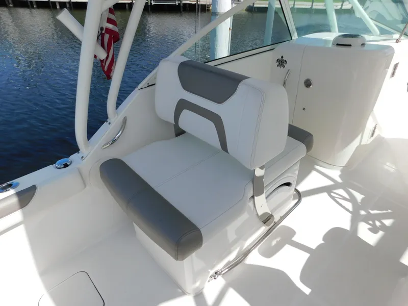 Slide: The Image of 2020 World Cat 230 DC boat interior with cushioned seating and American flag. - 17