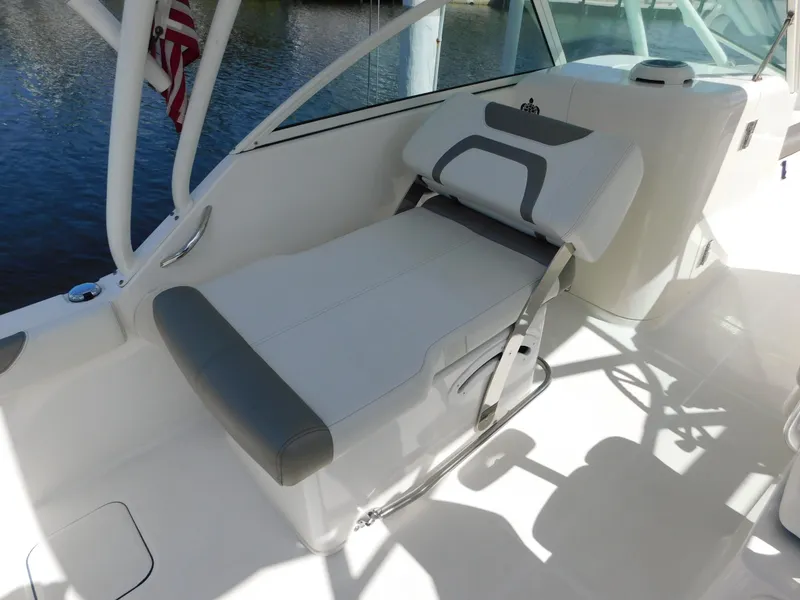 Slide: The Image of 2020 World Cat 230 DC boat interior with white and gray seating, near water. - 19