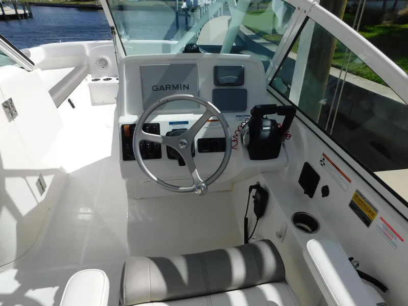 Slide: The Image of 2020 World Cat 230 DC boat cockpit with Garmin navigation system and steering wheel. - 21